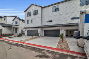 Modern inspired farmhouse featuring driveway, board and batten siding, and an attached garage