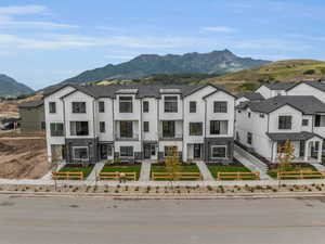 View of front of house with board and batten siding, stone siding, a mountain view, and a fenced front yard