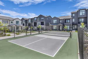 View of tennis court with a residential view