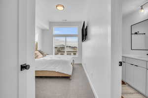 Bedroom featuring light carpet and baseboards
