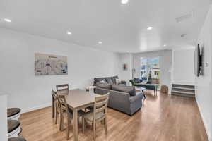 Dining area with recessed lighting, stairs, and light wood finished floors