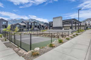 View of tennis court with a residential view and a mountain view