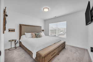 Bedroom featuring light carpet and baseboards