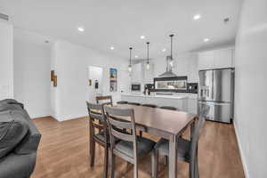 Dining room with light wood-style flooring and recessed lighting