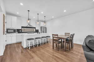 Dining space with dark wood-type flooring and recessed lighting