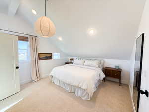 Bedroom with vaulted ceiling, light carpet, and recessed lighting