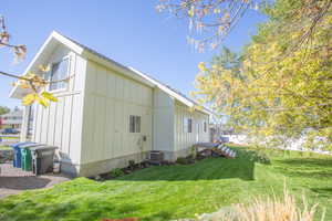 View of side of home with board and batten siding and a yard