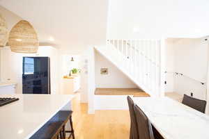 Dining area with recessed lighting, light wood-style flooring, and stairs