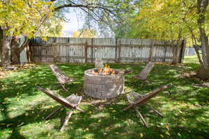 Fenced backyard featuring an outdoor fire pit