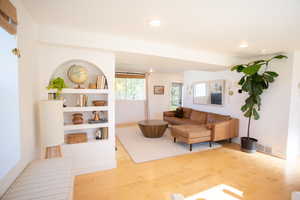 Living area with light wood-style floors and recessed lighting