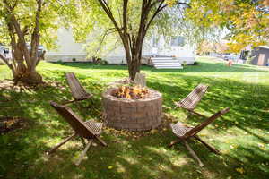 View of grassy yard featuring a fire pit