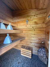 Relaxing sauna featuring wood walls and wooden ceiling