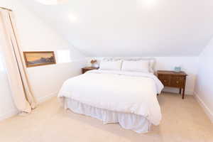 Bedroom featuring light carpet, recessed lighting, and vaulted ceiling