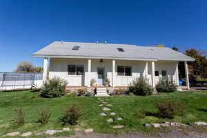 Rear view of property featuring roof with shingles, covered porch, and board and batten siding