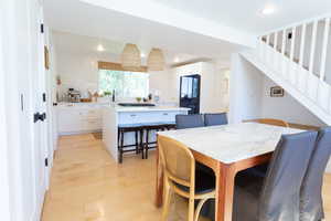 Dining area featuring light wood-type flooring, recessed lighting, and stairs