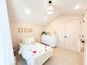 Bedroom with vaulted ceiling, light carpet, and recessed lighting
