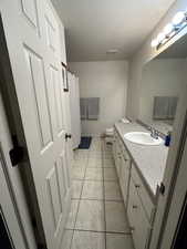 Full bathroom with vanity, light tile patterned floors, curtained shower, and a textured ceiling