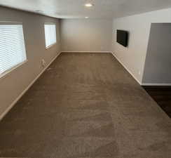 Spare room featuring a textured ceiling and dark colored carpet