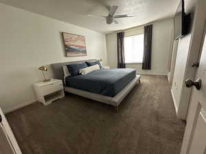 Carpeted bedroom with a textured ceiling and ceiling fan