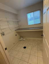 Laundry area featuring light tile patterned floors, washer hookup, and electric dryer hookup