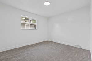 Carpeted spare room with baseboards