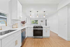Kitchen featuring white cabinetry, range with gas stovetop, a peninsula, crown molding, and recessed lighting