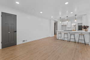 Living room with recessed lighting and light wood-style flooring