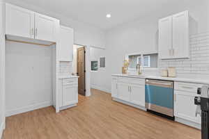 Kitchen featuring backsplash, white cabinets, and recessed lighting
