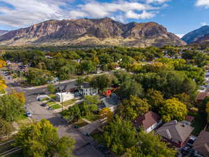 Aerial view of property and surrounding area with mountains and nearby suburban area
