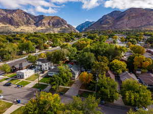 Aerial view of property and surrounding area featuring nearby suburban area and a mountainous background
