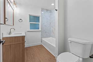 Full bath featuring vanity, light wood-type flooring, and shower / tub combination