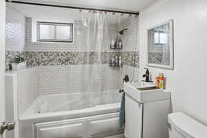 Bathroom with shower / bath combo with shower curtain and vanity