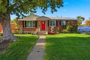 View of front of property featuring a front lawn and brick siding