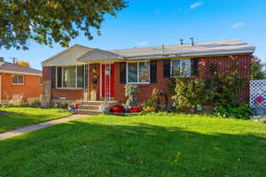 View of front facade featuring a front yard and brick siding