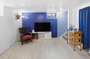 Living area with light wood-style floors and a textured ceiling