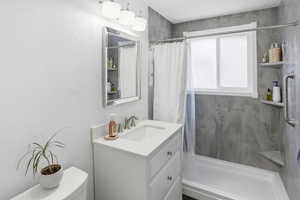 Bathroom featuring a shower stall, vanity, and a textured wall