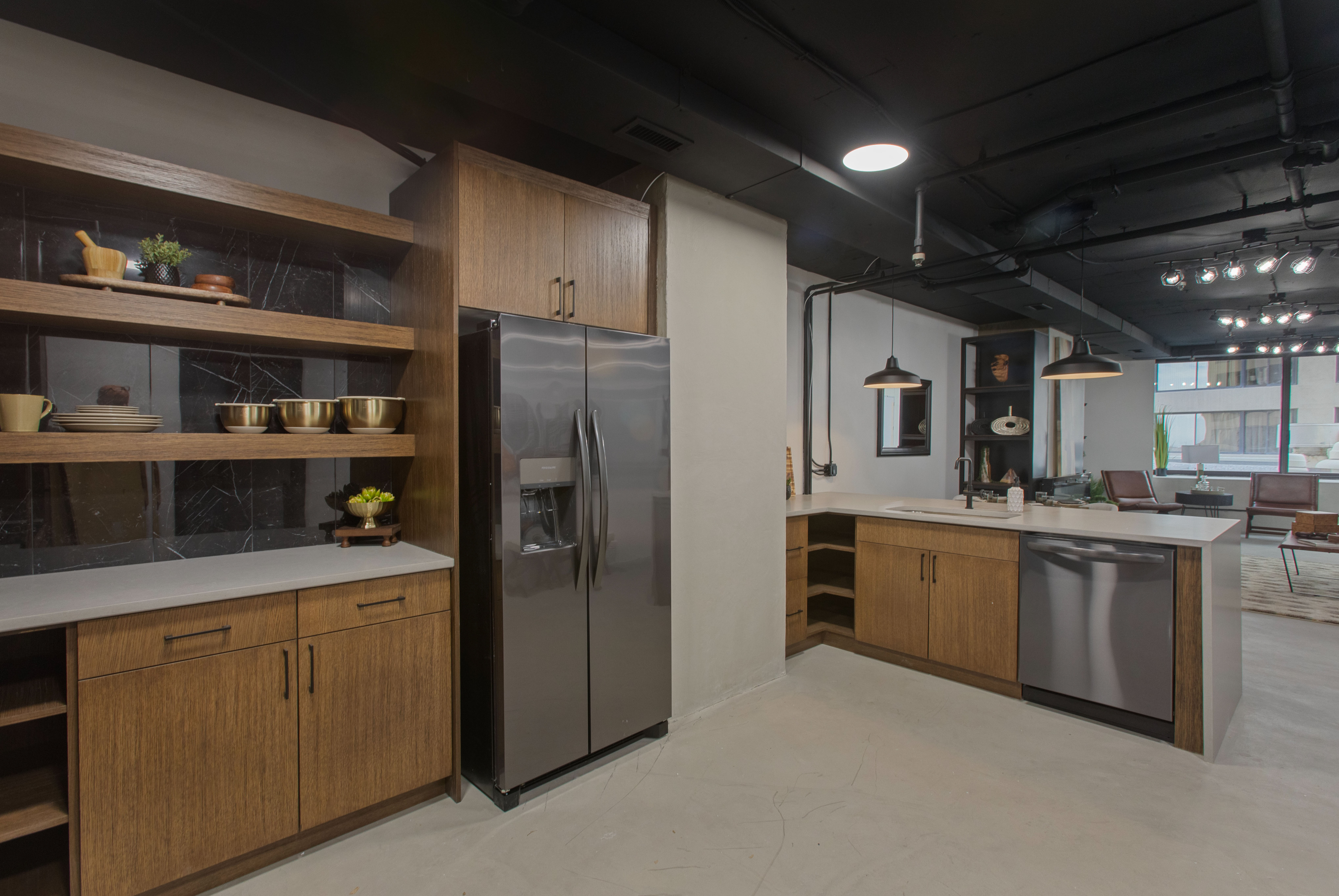 Kitchen with open shelves, brown cabinets, appliances with stainless steel finishes, decorative light fixtures, and a peninsula