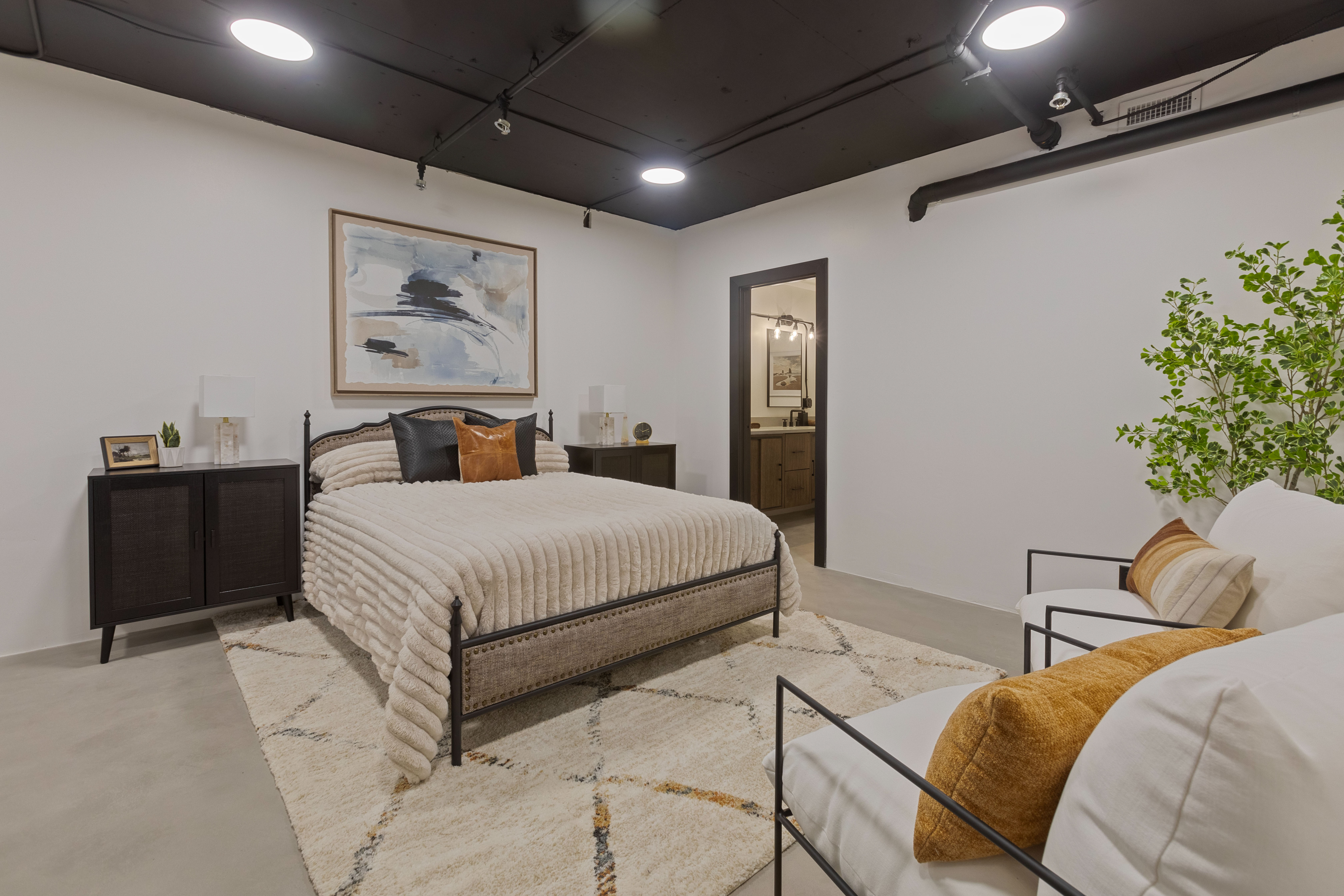 Bedroom with finished concrete flooring and ensuite bath
