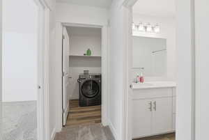 Laundry room with washer / dryer, carpet floors, and wood finished floors