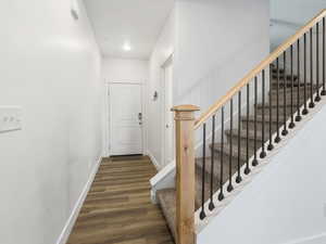 Stairs featuring wood finished floors and recessed lighting
