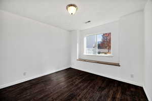 Empty room with dark wood-style flooring