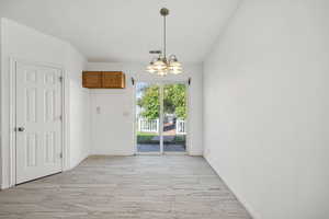 Unfurnished dining area featuring light wood-style floors and a chandelier