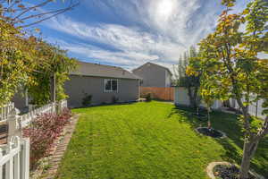 Fenced backyard featuring a storage unit