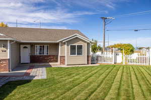 View of front of home featuring brick siding, a shingled roof, and covered porch