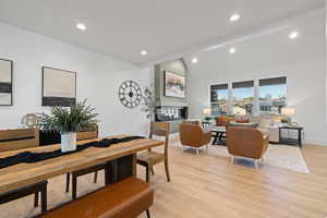 Dining space with lofted ceiling with beams, light wood finished floors, and recessed lighting