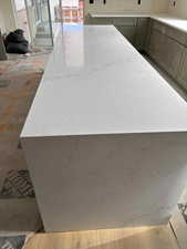 Kitchen view of light stone countertops and a kitchen island