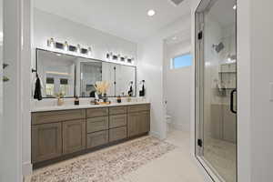 Full bath featuring a stall shower, double vanity, and recessed lighting