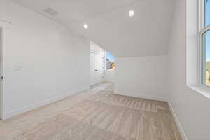 Bonus room featuring vaulted ceiling, light carpet, and recessed lighting