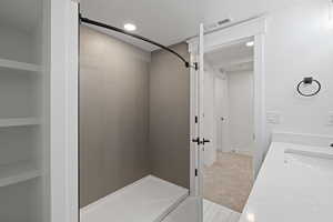 Bathroom featuring a stall shower, light carpet, recessed lighting, and vanity