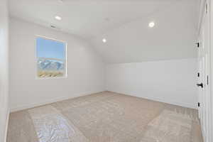 Additional living space with light carpet, lofted ceiling, and recessed lighting